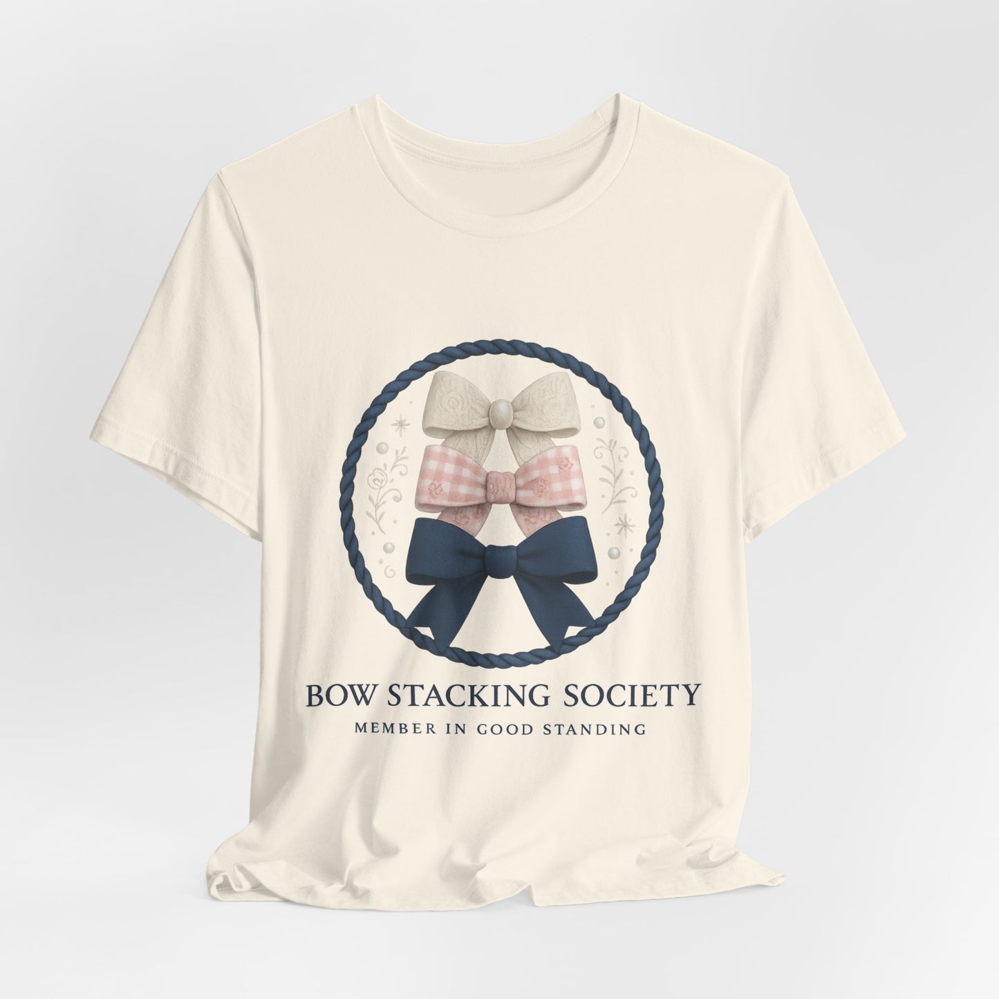 Cream T-shirt featuring Bow Stacking Society logo with stacked bows and rope motif.