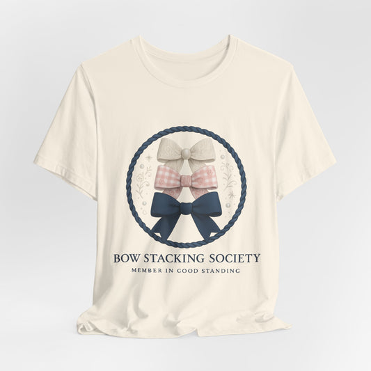 Cream T-shirt featuring Bow Stacking Society logo with stacked bows and rope motif.